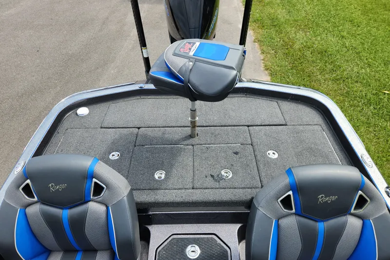 Slide: The Image of 2022 Ranger Z520R boat interior with blue-accented seats and carpeted deck. - 12