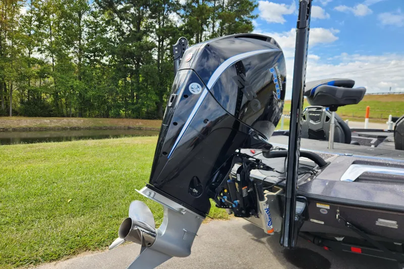 Slide: The Image of 2022 Ranger Z520R boat with powerful outboard motor, parked on grass by a serene lake. - 3