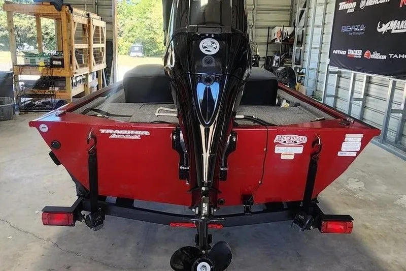 Slide: The Image of 2025 Tracker Pro 170 boat in garage, rear view with motor and trailer. - 3