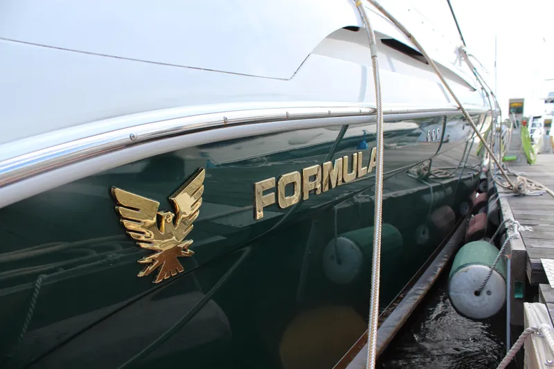 Slide: The Image of 2003 Formula 370 Super Sport yacht docked, featuring gold emblem and sleek design. - 6