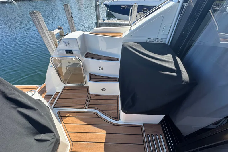 Slide: The Image of 2017 Sea Ray Sundancer 400 yacht deck with wooden flooring and dock view. - 11
