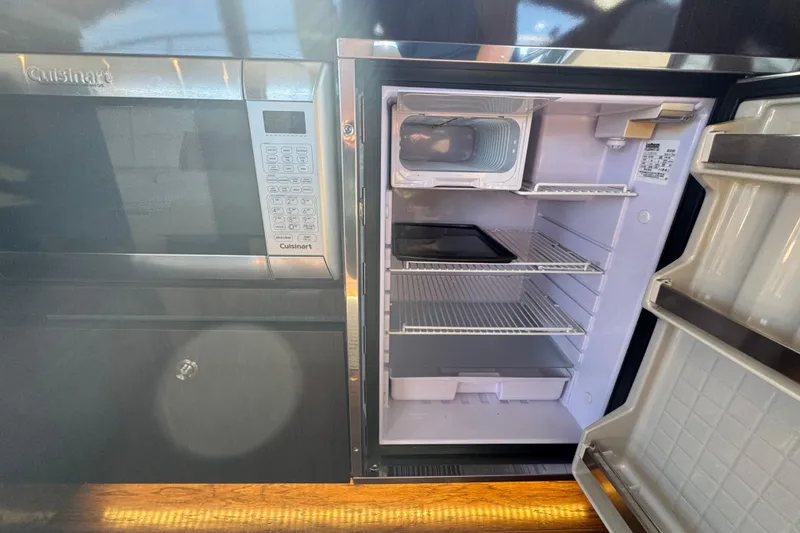 Slide: The Image of Kitchen area of 2017 Sea Ray Sundancer 400 with open fridge and microwave. - 21