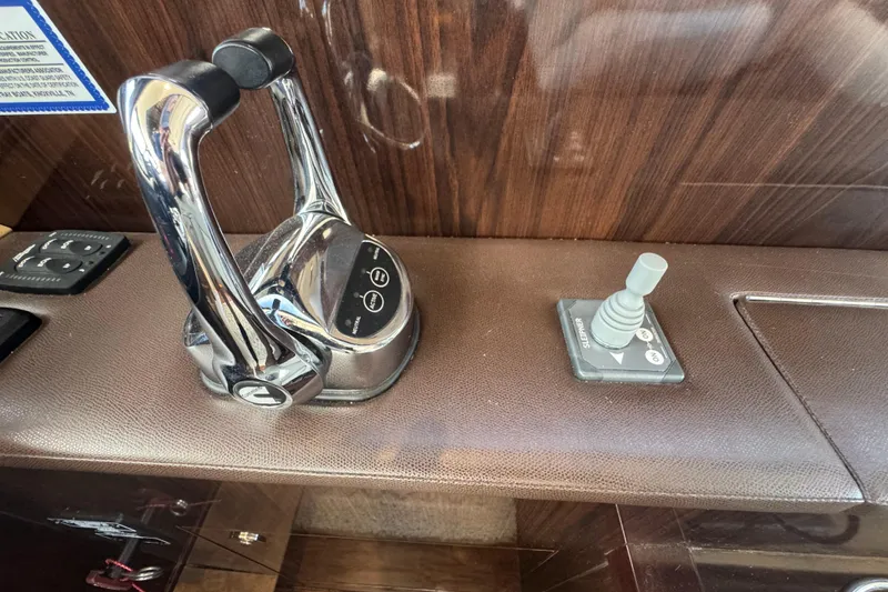 Slide: The Image of 2017 Sea Ray Sundancer 400 throttle and joystick controls on wooden dashboard. - 23