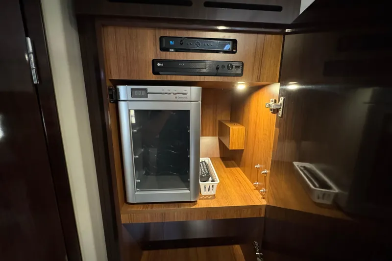 Slide: The Image of 2017 Sea Ray Sundancer 400 interior with a compact fridge and entertainment system. - 31