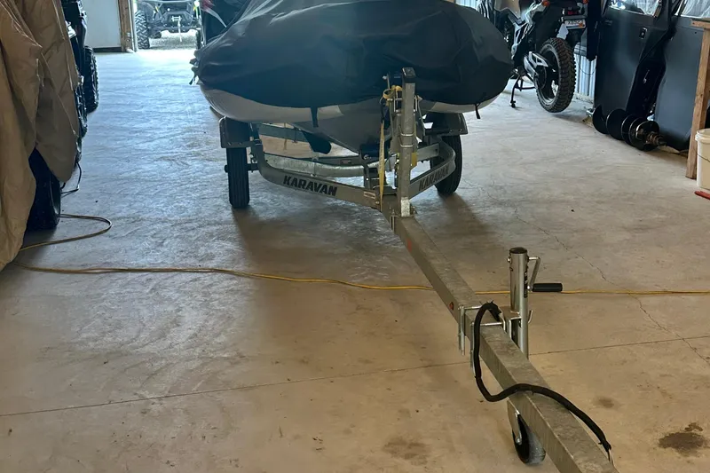 Slide: The Image of Covered boat on Karavan trailer in garage, surrounded by vehicles and equipment. - 47