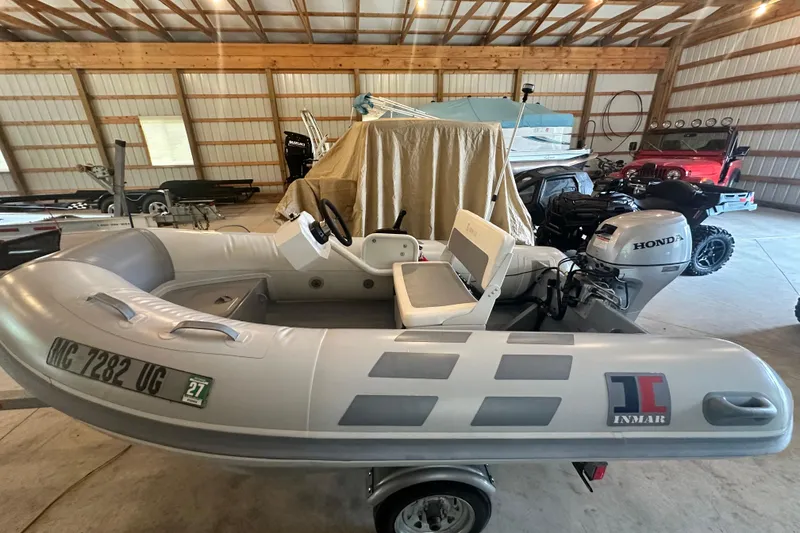 Slide: The Image of Inflatable boat with Honda motor in a garage, alongside a covered Sea Ray Sundancer 400, 2017 model. - 50
