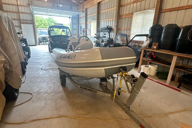 Slide: The Image of Inflatable boat on Karavan trailer inside a garage, surrounded by various equipment. - 55