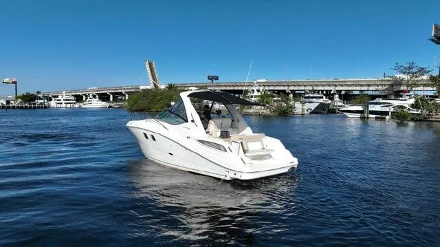 The Image of 2012 Sea Ray 330 Sundancer boat cruising on a sunny day near a bridge. - 0