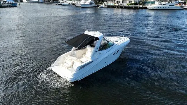 Slide: The Image of 2012 Sea Ray 330 Sundancer cruising on a calm waterway, surrounded by other boats. - 1