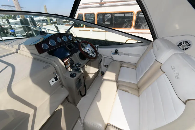 Slide: The Image of 2012 Sea Ray 330 Sundancer cockpit with leather seating and modern dashboard controls. - 11