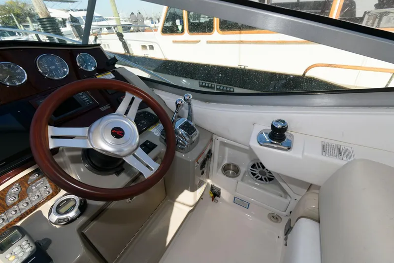 Slide: The Image of 2012 Sea Ray 330 Sundancer helm with steering wheel and control panel. - 12