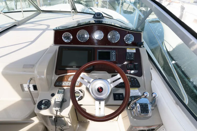 Slide: The Image of Cockpit of 2012 Sea Ray 330 Sundancer with steering wheel and control panel. - 13