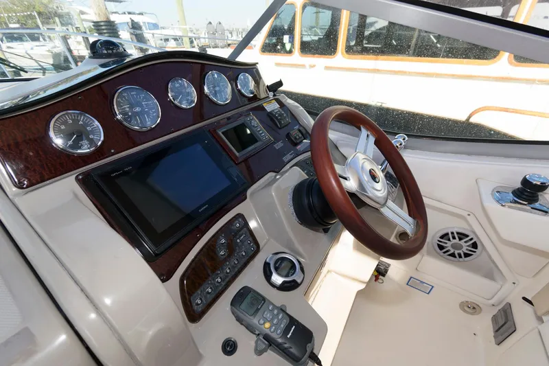Slide: The Image of 2012 Sea Ray 330 Sundancer helm with gauges, steering wheel, and navigation system. - 14