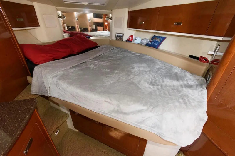 Slide: The Image of Cozy cabin interior of 2012 Sea Ray 330 Sundancer with bed and wooden cabinetry. - 19