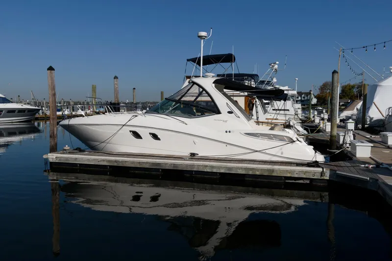 Slide: The Image of 2012 Sea Ray 330 Sundancer yacht docked at marina, reflecting on calm water. - 4