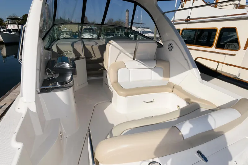 Slide: The Image of 2012 Sea Ray 330 Sundancer boat interior with beige seating and sleek design. - 5