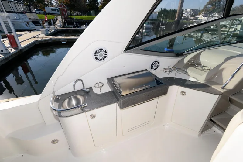 Slide: The Image of 2012 Sea Ray 330 Sundancer yacht with outdoor kitchenette and sink at marina. - 8