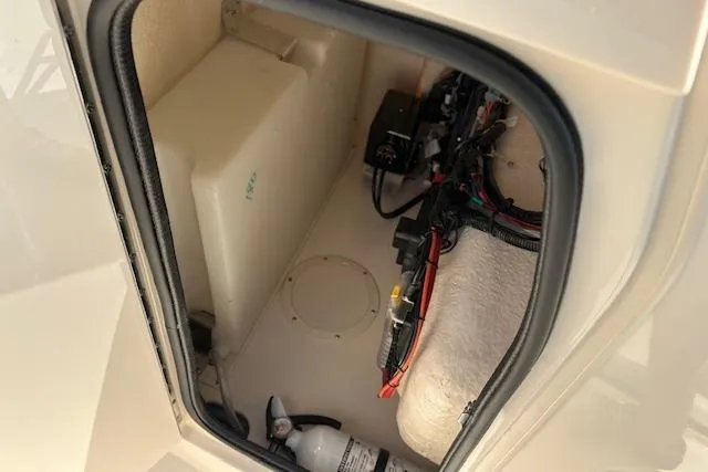 Slide: The Image of 2026 Grady-White Fisherman 180 storage compartment with wiring and fire extinguisher. - 14