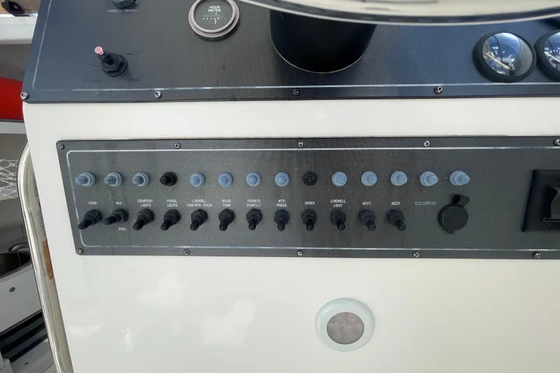 Slide: The Image of Control panel of a 1997 Wellcraft 240 Coastal boat with various switches and gauges. - 12
