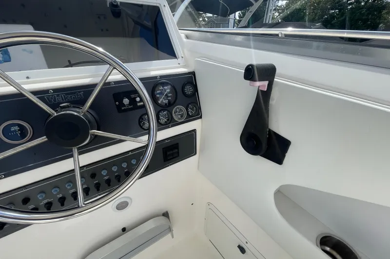 Slide: The Image of 1997 Wellcraft 240 Coastal boat dashboard with steering wheel and gauges. - 14