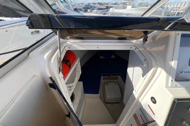 Slide: The Image of 1997 Wellcraft 240 Coastal cabin interior with storage and seating area. - 24