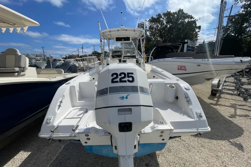 Slide: The Image of 1997 Wellcraft 240 Coastal boat with outboard motor, displayed for sale in a marina. - 4