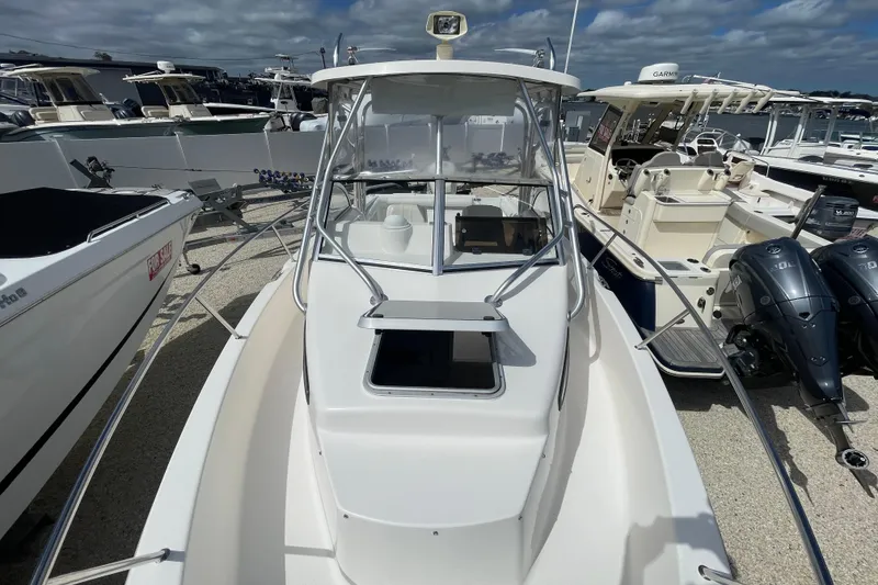 Slide: The Image of 1997 Wellcraft 240 Coastal boat with cabin, docked among other vessels under cloudy skies. - 6