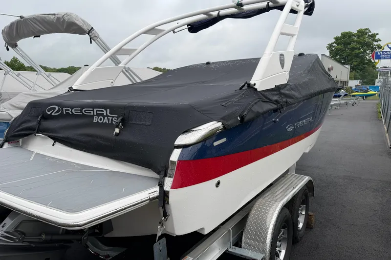 Slide: The Image of 2026 Regal LS2 boat with cover on trailer, parked outdoors. - 11