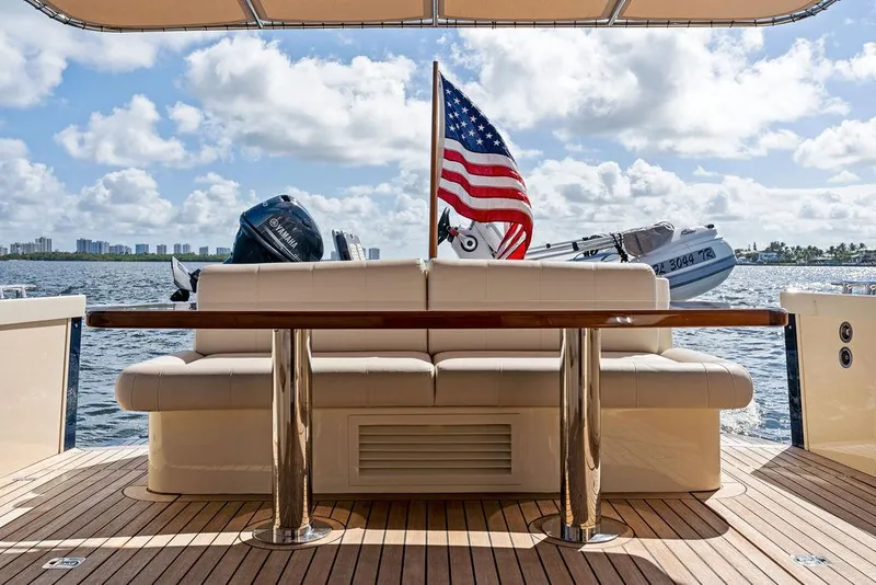 Slide: The Image of 2018 Palm Beach Motor Yachts PB55 Flybridge deck with American flag and scenic water view. - 15