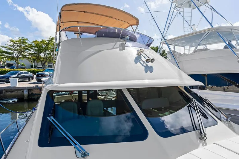 Slide: The Image of 2018 Palm Beach Motor Yachts PB55 Flybridge docked, showcasing sleek design and flybridge canopy. - 25