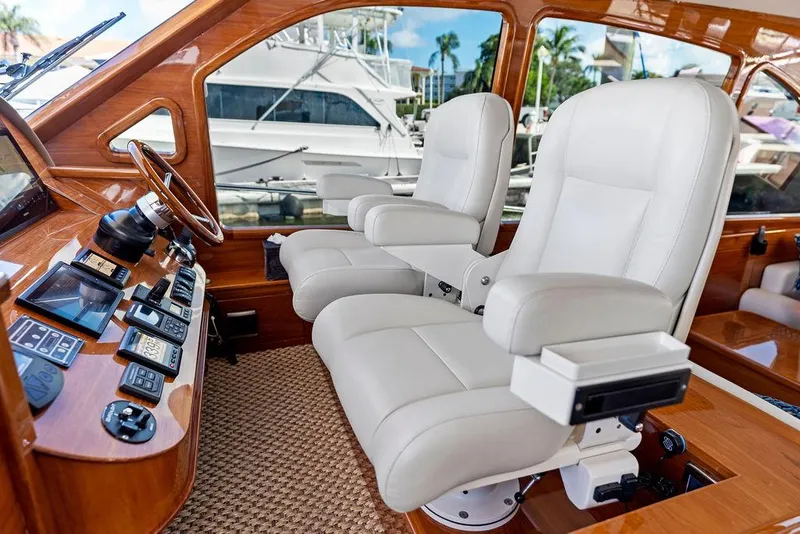 Slide: The Image of Luxurious 2018 Palm Beach Motor Yachts PB55 Flybridge helm with plush white captain chairs. - 3