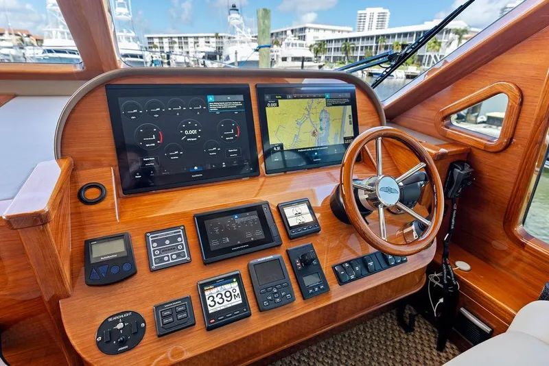 Slide: The Image of Helm of 2018 Palm Beach Motor Yachts PB55 Flybridge with navigation screens and controls. - 38