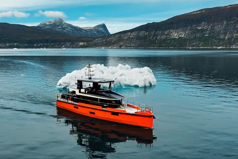 Slide: The Image of 2023 Naval Yachts XPM 78 navigating icy waters with mountainous backdrop. - 2