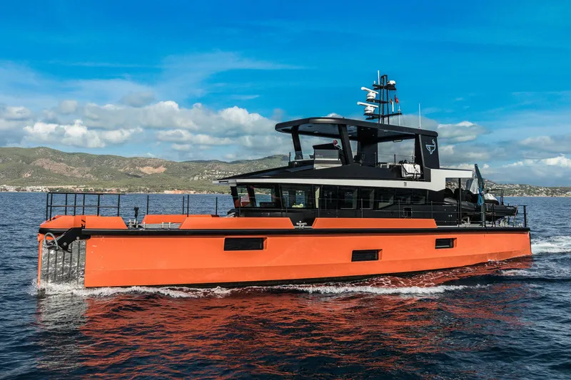 Slide: The Image of 2023 Naval Yachts XPM 78 cruising on open water, vibrant orange hull, scenic background. - 28