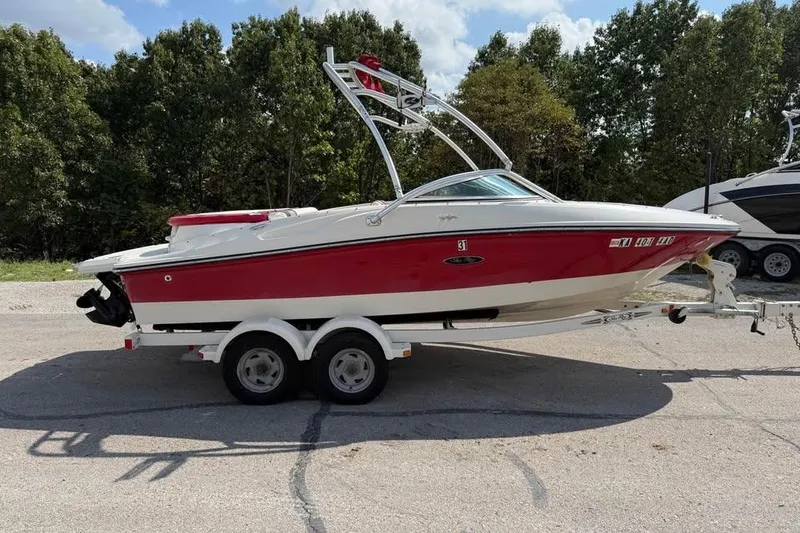 The Image of 2006 Sea Ray 195 Sport boat on trailer, red and white, parked outdoors. - 0