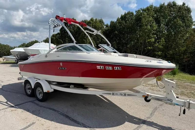 Slide: The Image of 2006 Sea Ray 195 Sport boat on trailer, red and white, parked outdoors. - 2