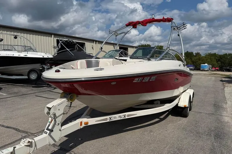 Slide: The Image of 2006 Sea Ray 195 Sport boat on trailer, red and white, parked outdoors. - 3
