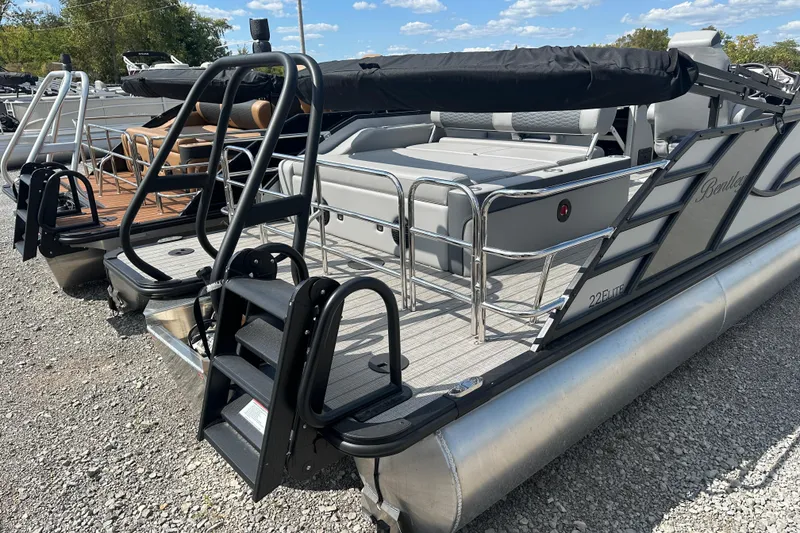 Slide: The Image of 2025 Bentley Pontoons 223 Elite Swingback, sleek design, docked on gravel, sunny day. - 4