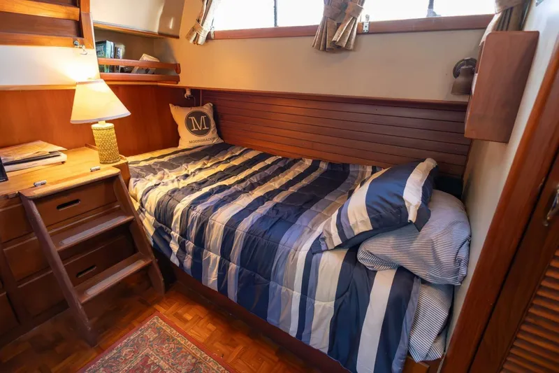 Slide: The Image of Cozy cabin interior of 1985 Grand Banks 42 Classic yacht with striped bedding and wooden furnishings. - 12
