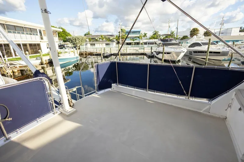 Slide: The Image of 1985 Grand Banks 42 Classic yacht deck with marina view, featuring blue railings and clear skies. - 28