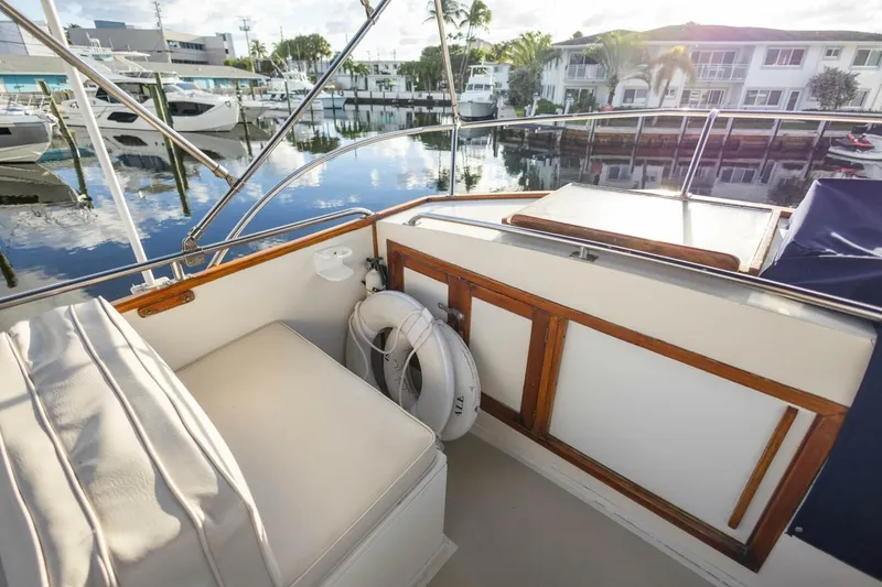 Slide: The Image of 1985 Grand Banks 42 Classic yacht deck with seating and life preserver, docked at marina. - 29
