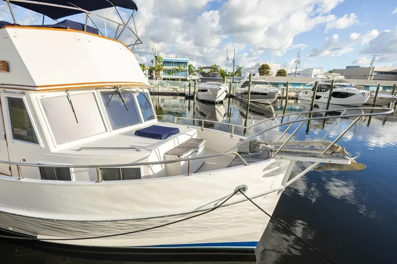 Slide: The Image of 1985 Grand Banks 42 Classic yacht docked in a marina under a partly cloudy sky. - 3