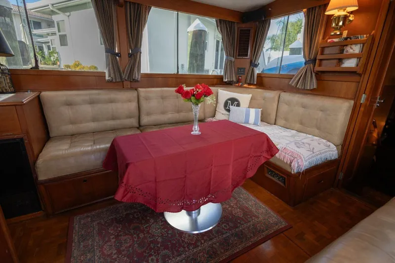 Slide: The Image of 1985 Grand Banks 42 Classic yacht interior with cozy seating and red tablecloth. - 9