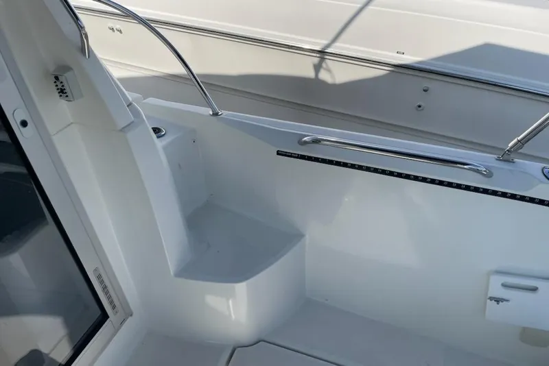 Slide: The Image of 2019 Beneteau Antares 23 boat interior with sleek white seating and stainless steel railing. - 13