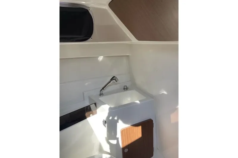 Slide: The Image of Interior of 2019 Beneteau Antares 23, featuring a compact sink and wooden cabinet. - 15