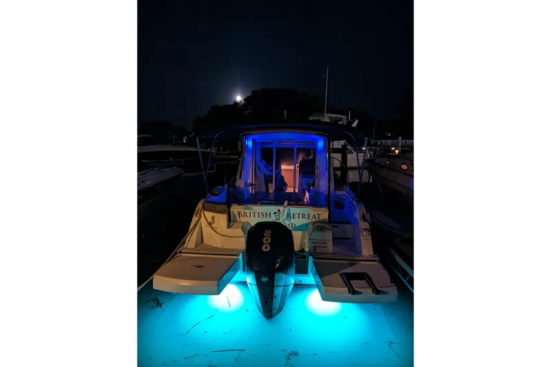 Slide: The Image of Beneteau Antares 23 boat, 2019 model, illuminated at night with blue underwater lights. - 3
