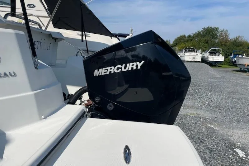 Slide: The Image of 2019 Beneteau Antares 23 with Mercury outboard motor, docked on gravel lot. - 8