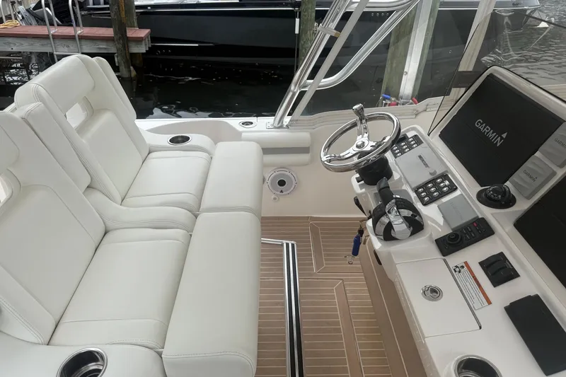 Slide: The Image of 2021 Intrepid 409 Valor boat interior with white seating and Garmin navigation system. - 16