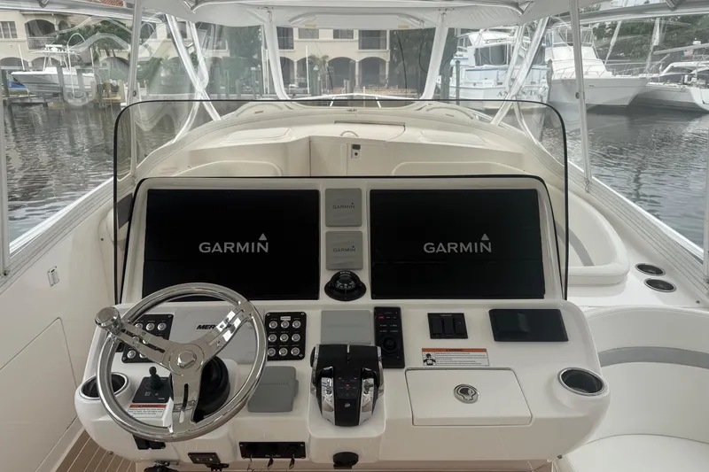 Slide: The Image of 2021 Intrepid 409 Valor boat helm with Garmin navigation displays and controls. - 17
