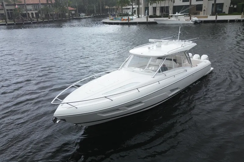 Slide: The Image of 2021 Intrepid 409 Valor boat on calm water under clear blue sky. - 2